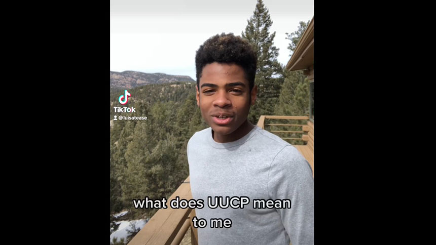 Nigel standing on a porch with mountains and trees behind him.