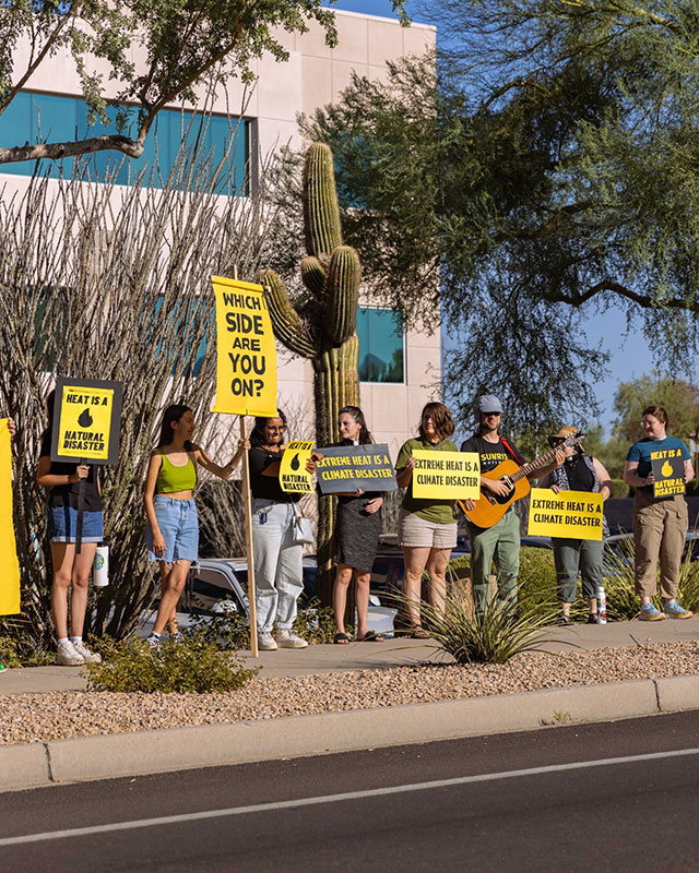 A group of people protesting holding climate disaster signs