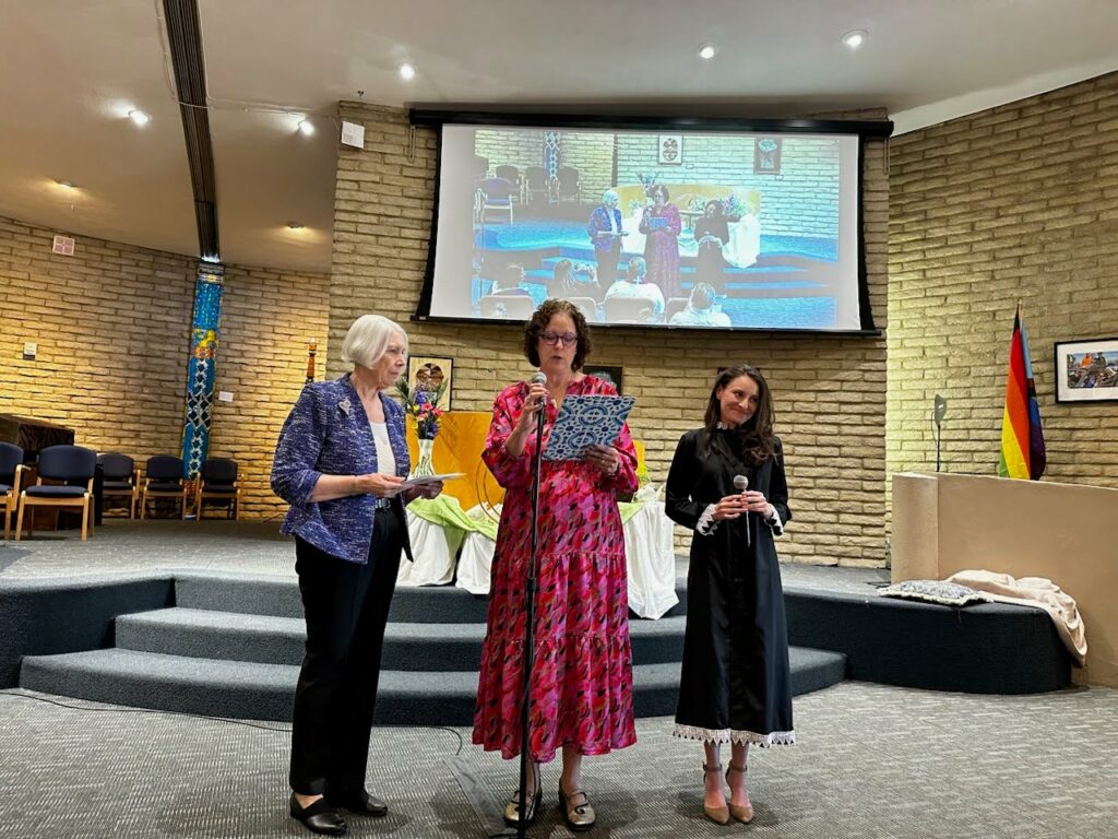 Bunny Hodas speaking to the group with Brigitta Vieyra at her ordination celebration. 