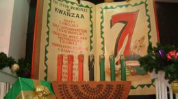 Kwanzaa candles with 7 principles of Kwanzaa on book in background