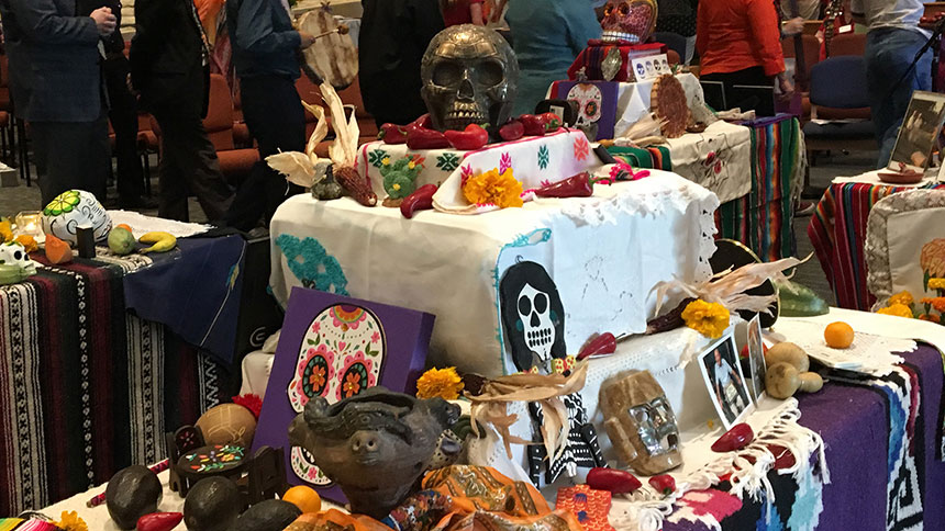 A display containing many skulls in various forms from a previous Dia De Los Muertos service